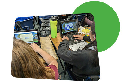 Over the shoulder view of student playing Reflex on their laptops.