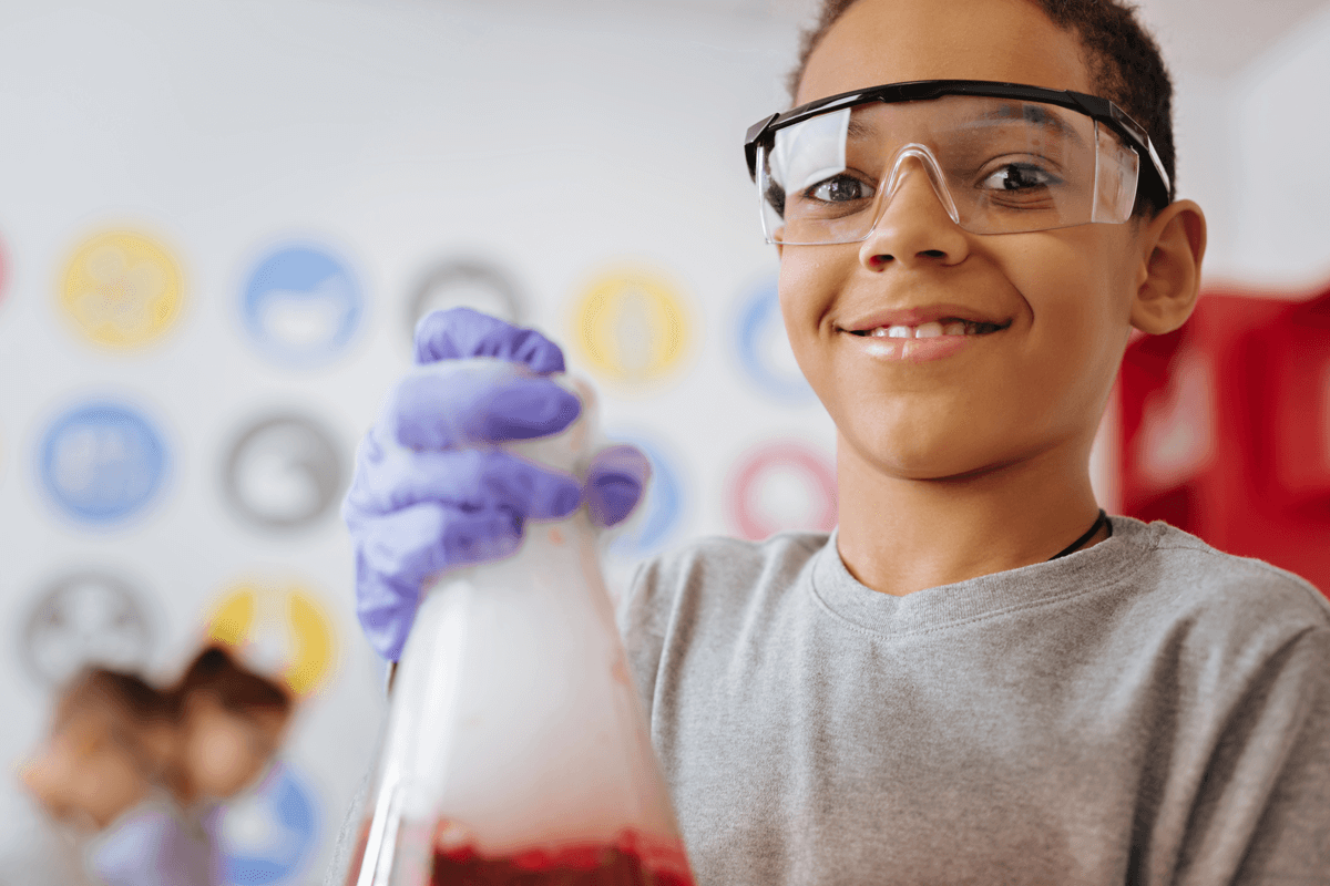 Photo of a young boy holding a beaker